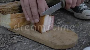 在户外的木板上，用刀子把猪肚切好。 公园里的秋天野餐。 4k. 4k录像。 <strong>慢慢慢慢</strong>
